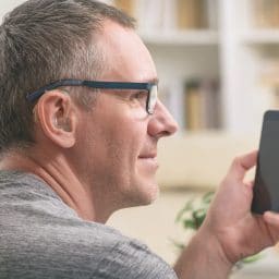 Man with a hearing aid and smartphone